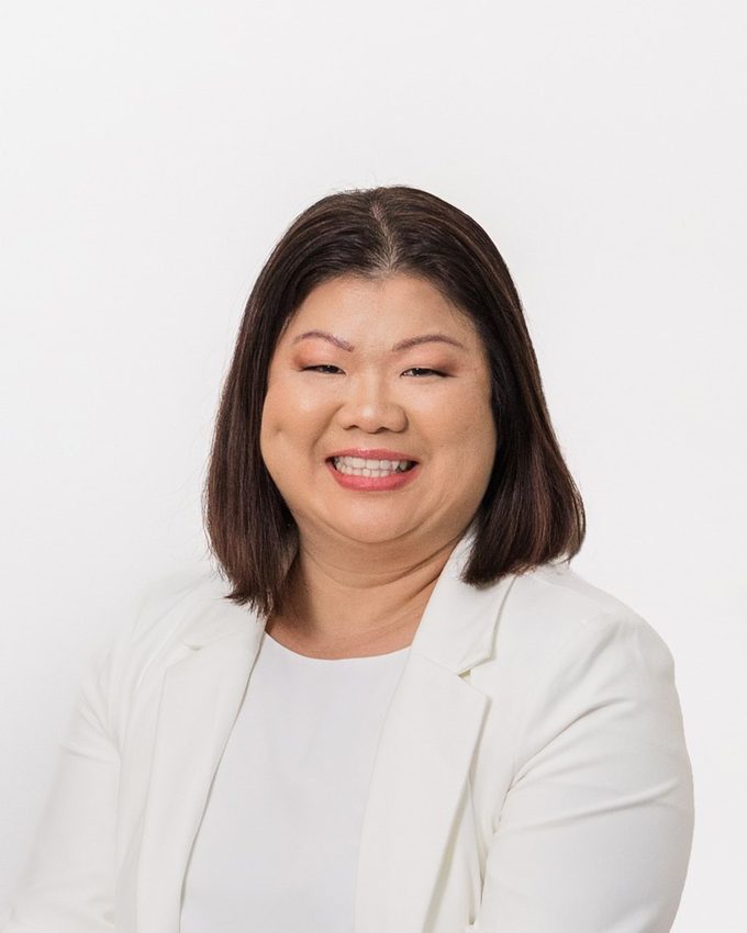 Portrait of Joanna, Practice Manager, smiling, in a white jacket against a plain white background